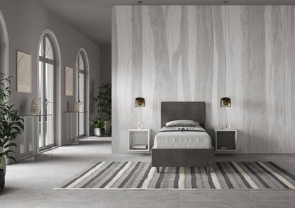Letto singolo contenitore imbottito 90x200 microfibra Adele grigio scuro in ampio ambiente luminoso. Perfetto per arredare camere minimaliste.