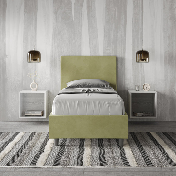 Letto singolo Adele 80x210 verde salvia in microfibra, ambientato in camera moderna con pareti effetto legno e comodini sospesi.