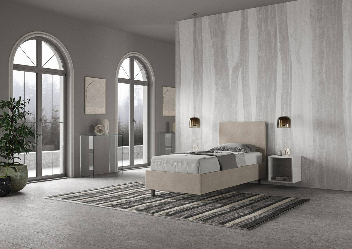 Letto singolo contenitore imbottito 90x200 microfibra Adele beige visto lateralmente. Stile moderno con contenitore integrato e testata imbottita.
