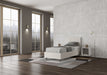 Letto singolo Adele bianco con contenitore opzionale, struttura elegante in similpelle, ambientato in camera con parquet e grandi finestre.