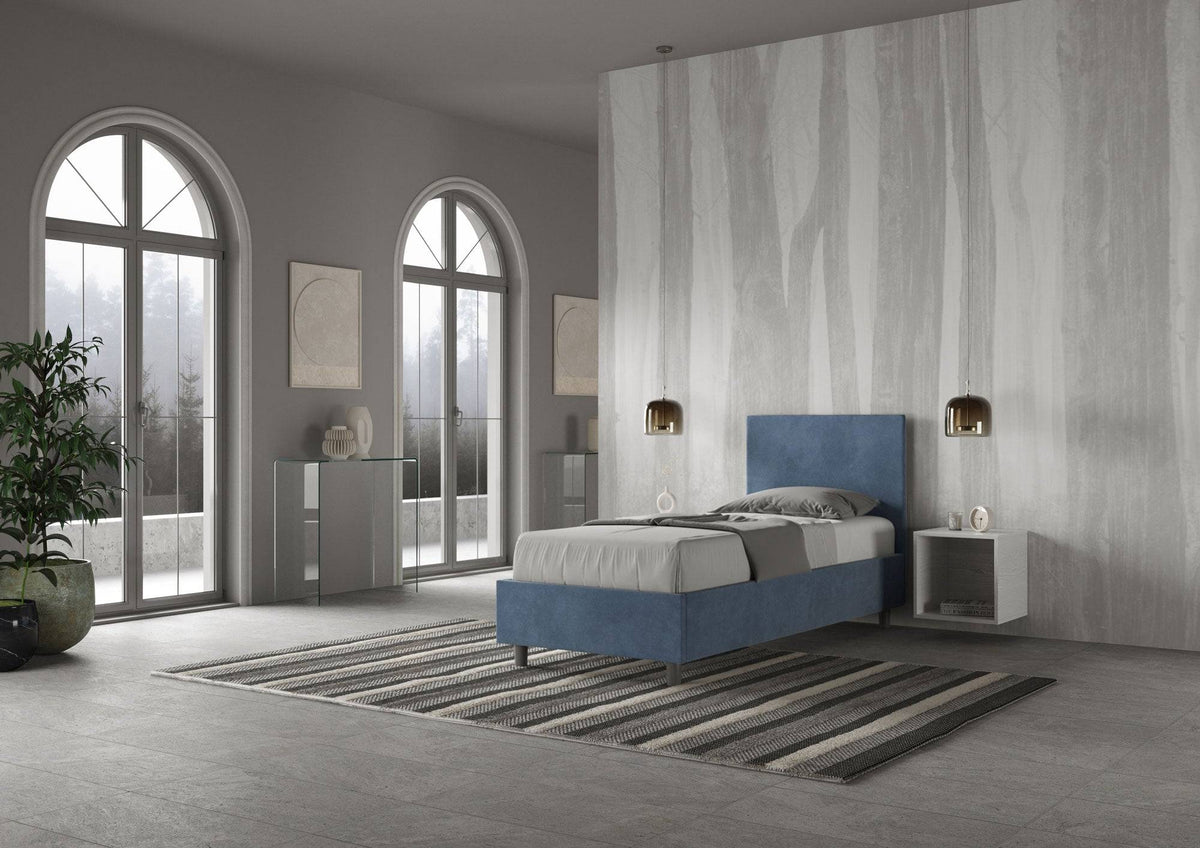 Letto singolo contenitore imbottito 90x200 microfibra Adele blu navy in ambiente spazioso. Design moderno e contenitore integrato.