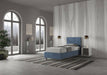 Letto singolo contenitore imbottito 90x200 microfibra Adele blu navy in ambiente spazioso. Design moderno e contenitore integrato.