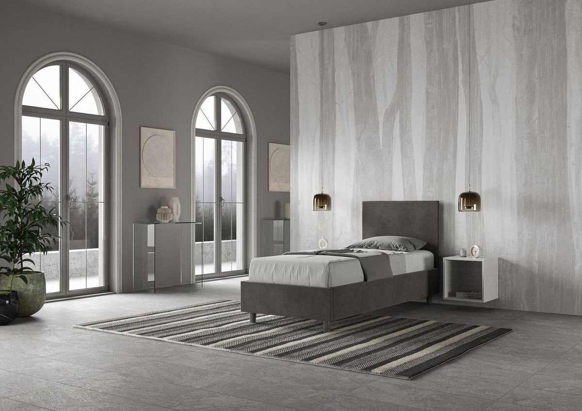 Letto singolo contenitore imbottito 90x200 microfibra Adele grigio scuro visto lateralmente. Stile moderno con testata imbottita e struttura compatta.