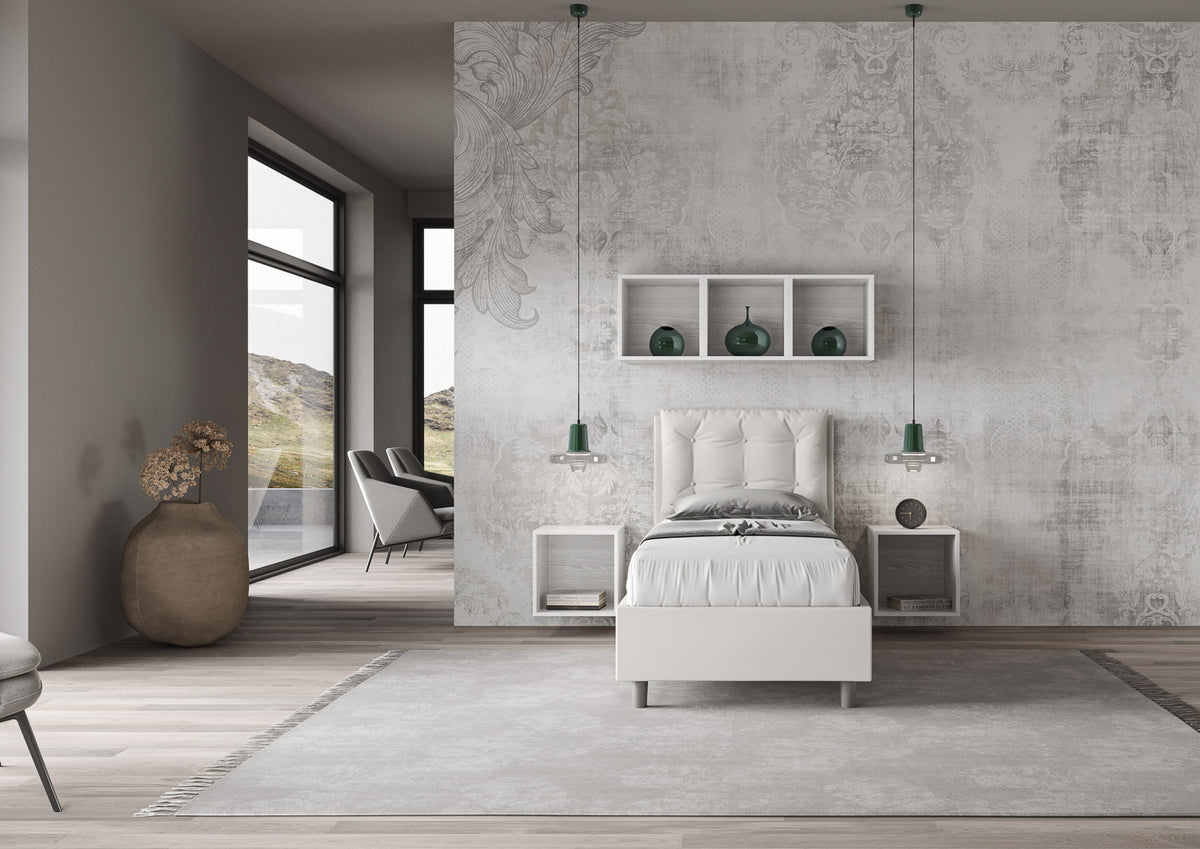 Camera moderna con letto singolo Annalisa bianco in similpelle, testata trapuntata e arredamento minimalista.