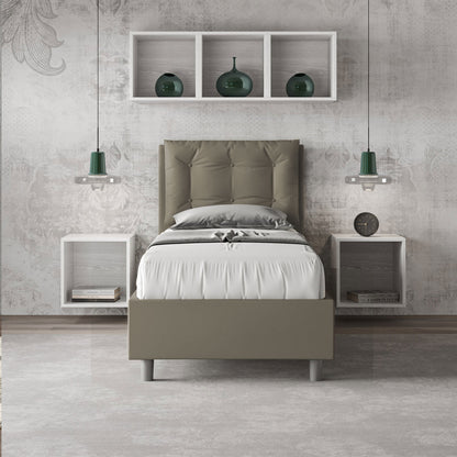 Letto singolo Annalisa verde oliva in similpelle con testata imbottita, posizionato in una camera elegante con mensole e lampade sospese.