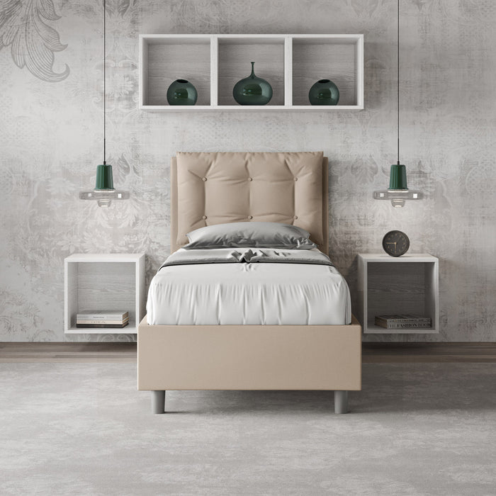 Letto singolo Annalisa beige in similpelle con testata imbottita, inserito in una camera elegante con mensole e decorazioni.