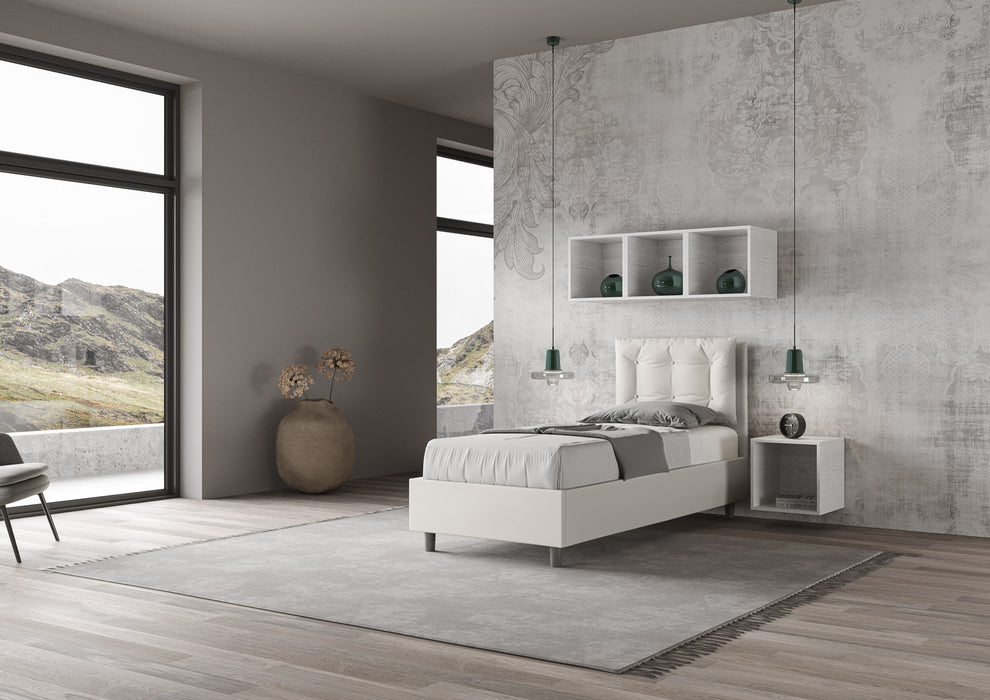 Letto singolo Annalisa bianco in similpelle con testata imbottita, collocato in una stanza luminosa con vista panoramica.