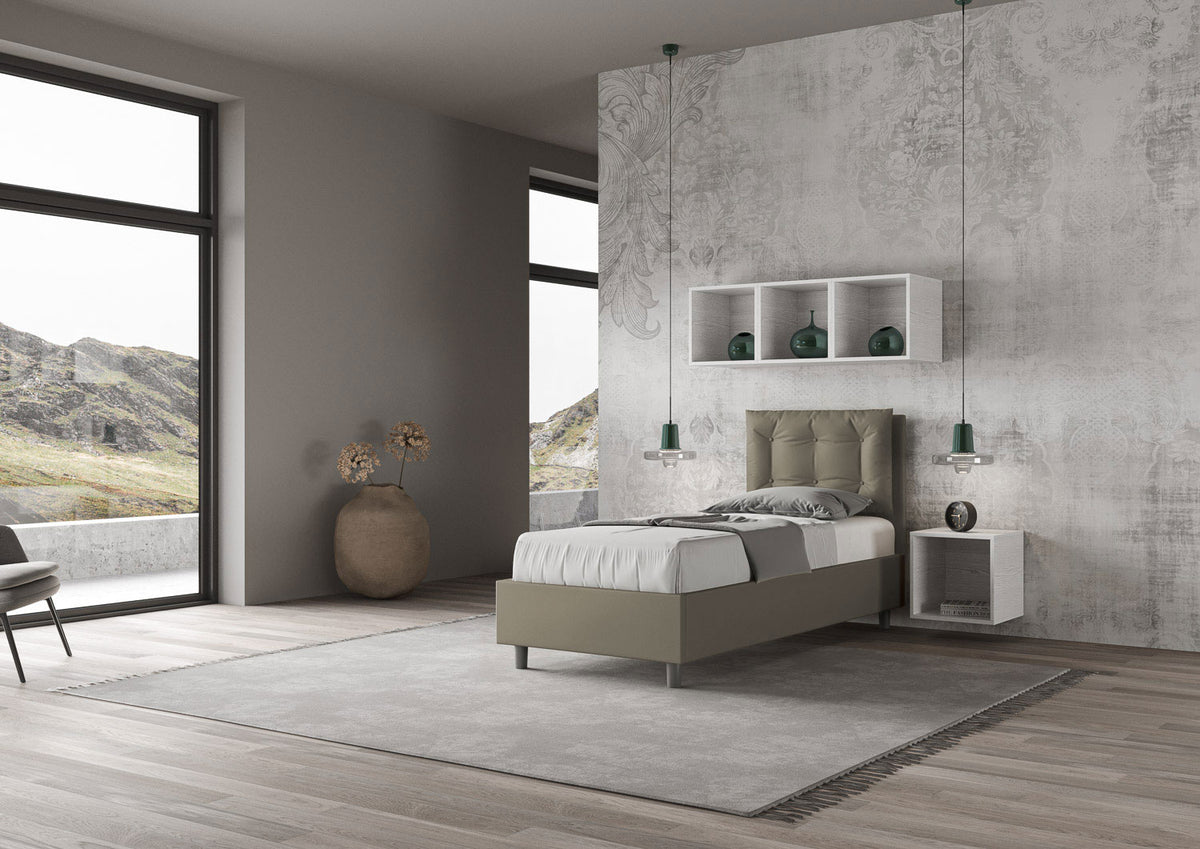 Letto singolo Annalisa verde oliva in similpelle con testata imbottita, collocato in una stanza luminosa con vista panoramica.