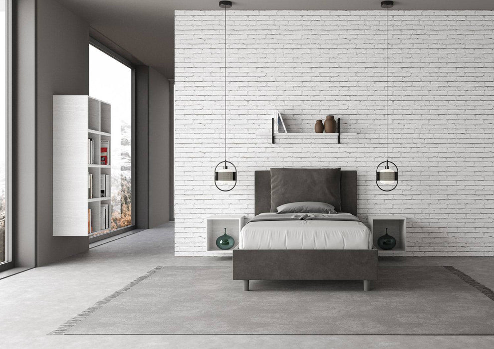 Letto singolo contenitore imbottito Antea grigio scuro in microfibra, ambientato in una stanza luminosa con design contemporaneo.