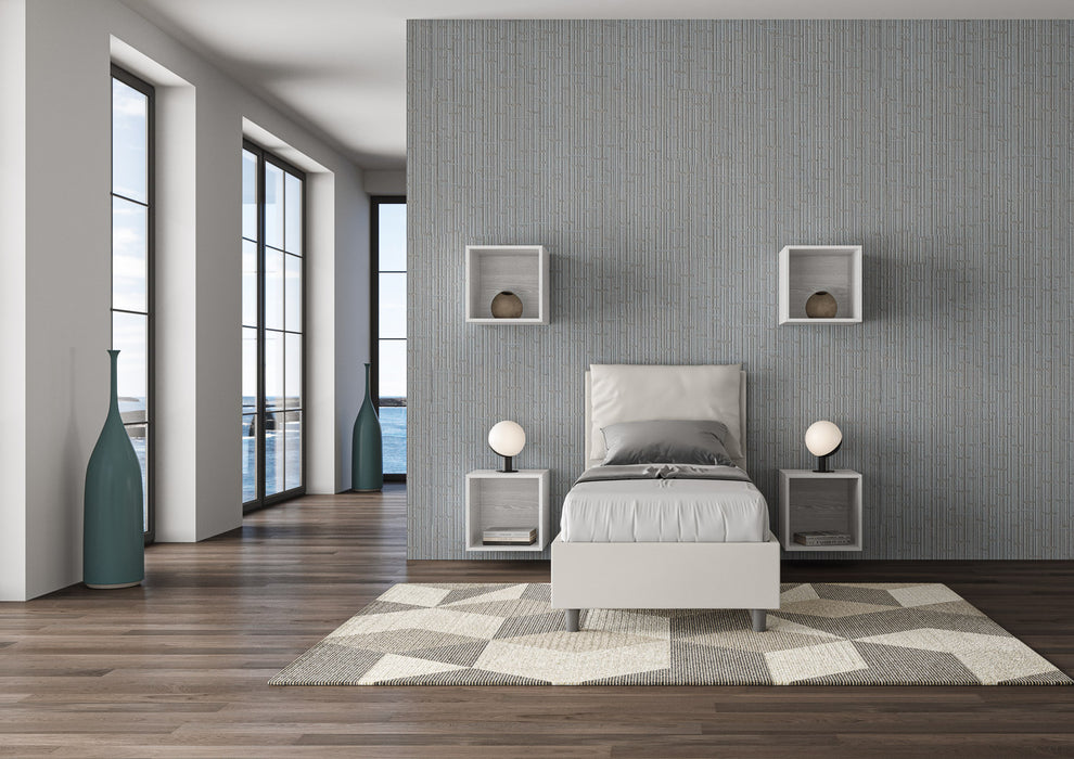 Letto singolo imbottito Antea bianco in similpelle con contenitore, inserito in una camera luminosa e moderna con vista mare.