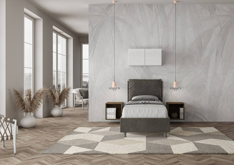 Letto singolo contenitore imbottito 90x210 microfibra Antea in grigio scuro, inserito in un ambiente moderno e luminoso.