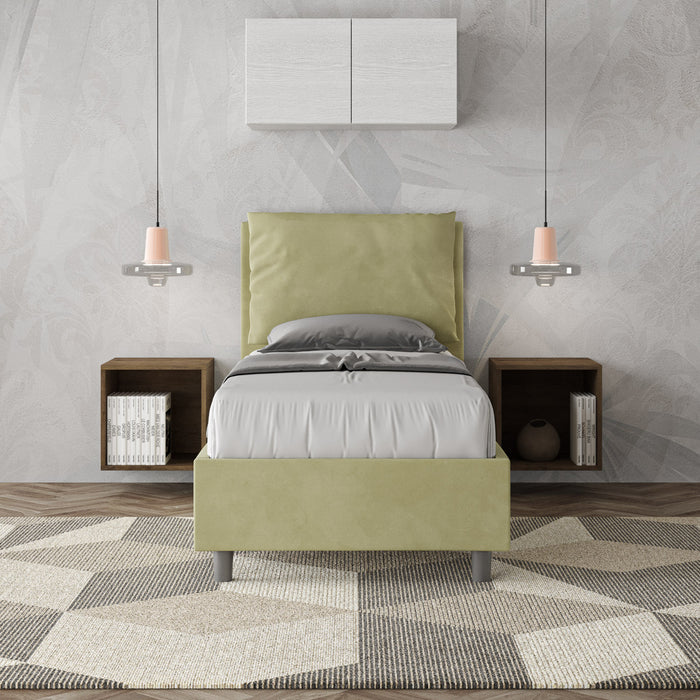 Letto singolo Antea verde pastello in microfibra, inserito in una camera moderna con comodini sospesi e illuminazione pendente.