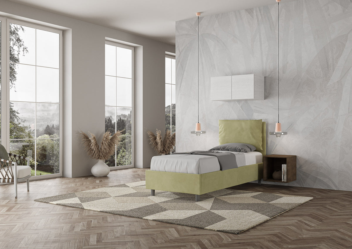 Letto Antea verde salvia 80x190 con struttura imbottita, ambientato in camera luminosa con vista e arredamento minimal.