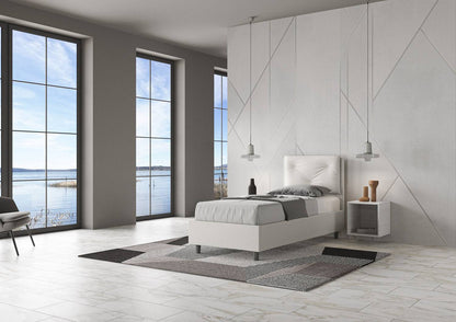 Letto singolo 80x200 in similpelle bianca con testiera trapuntata, posizionato in una stanza luminosa con vista panoramica.