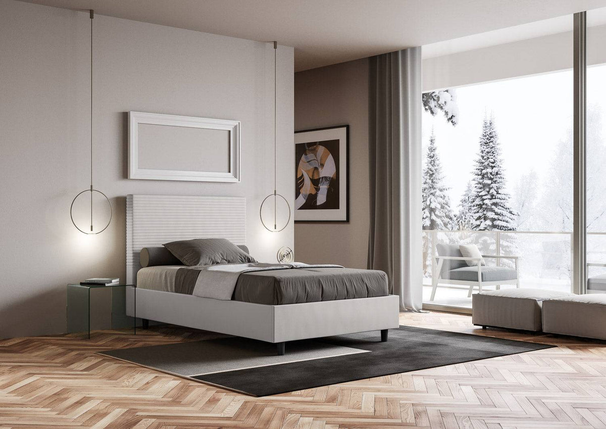 Letto Focus bianco con contenitore, ambientato in una stanza luminosa con vista invernale e arredi contemporanei.