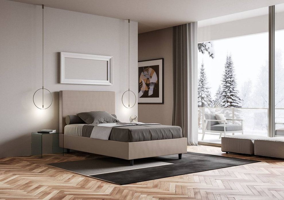 Letto Focus beige con contenitore, ambientato in una stanza luminosa con vista invernale e arredi contemporanei.