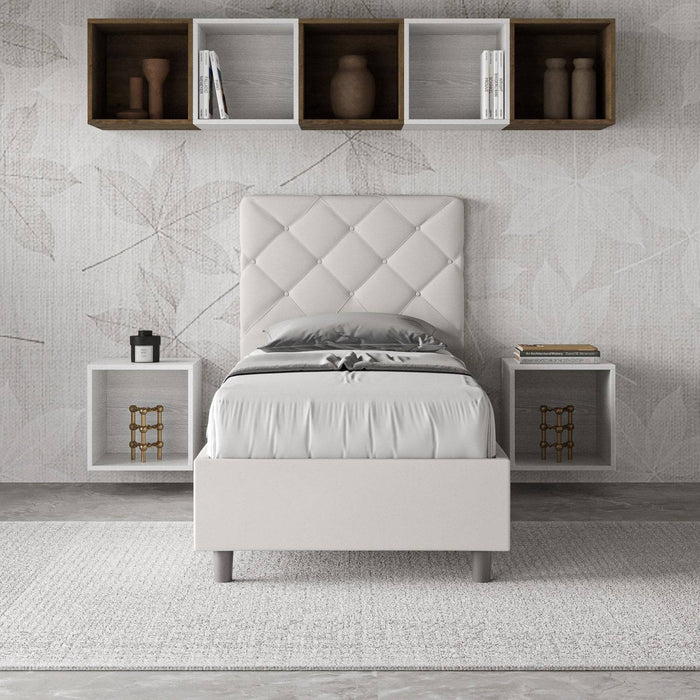 Letto singolo Priya bianco in similpelle con contenitore, ideale per arredare con eleganza e funzionalità ambienti contemporanei.