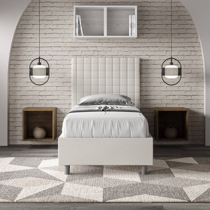 Letto singolo imbottito similpelle Sunny bianco in ambiente moderno con parete in mattoni e comodini a incasso, stile minimalista.