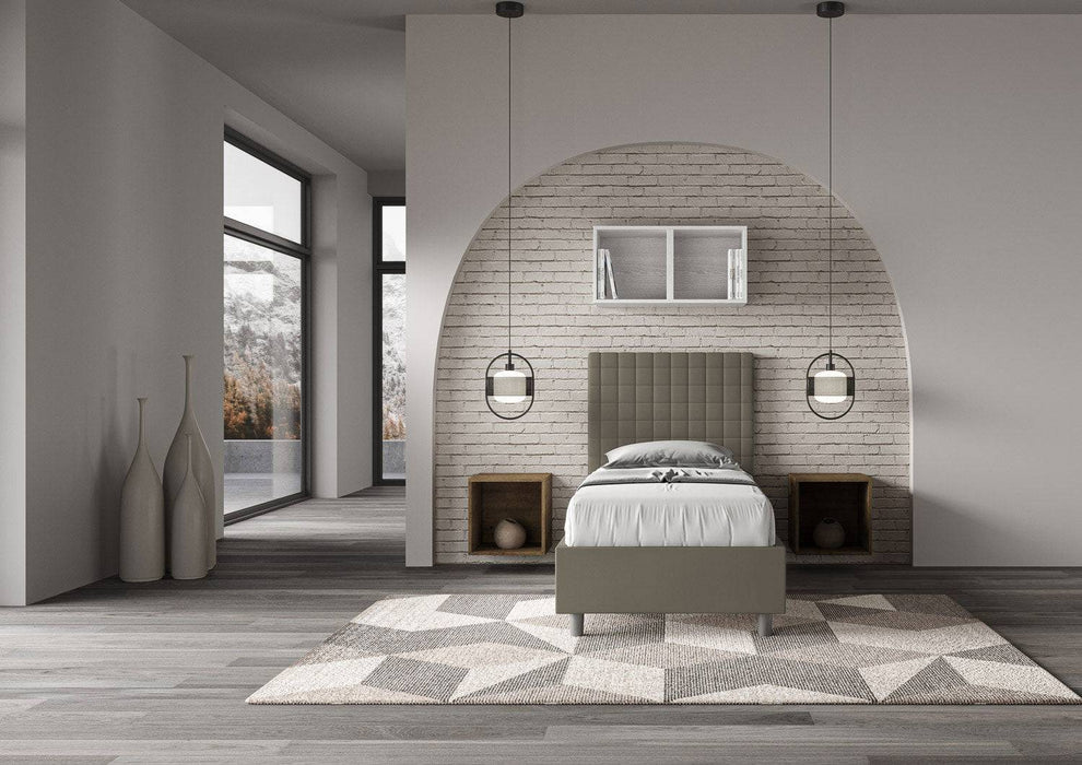 Letto singolo contenitore imbottito similpelle Sunny grigio tortora posizionato in camera luminosa con design contemporaneo e dettagli geometrici.