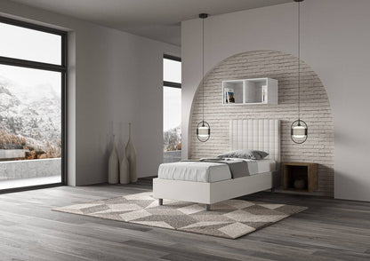 Letto singolo imbottito similpelle Sunny bianco visto lateralmente in stanza moderna con vista panoramica e arredamento essenziale.