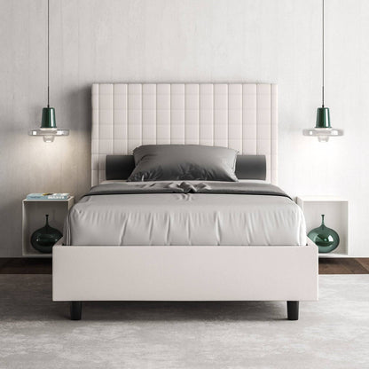 Letto singolo contenitore imbottito similpelle Sunny bianco in camera moderna con comodini integrati e illuminazione sospesa.