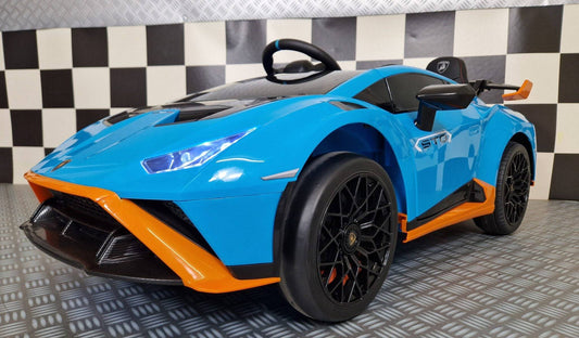 Vista frontale dell'auto elettrica per bambini Lamborghini Huracan STO blu con fari LED, dettagli aerodinamici e logo Lamborghini, perfetta per divertimento.