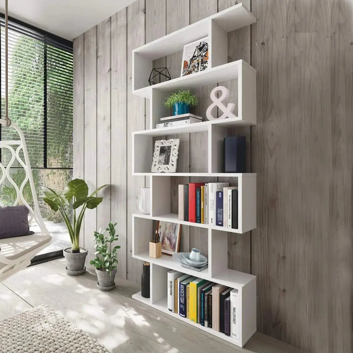 Libreria alta Athena bianca con design minimalista, posizionata in un ambiente luminoso con piante e decorazioni eleganti.