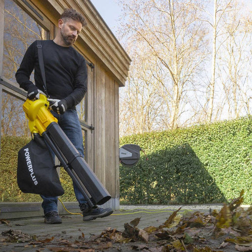 Uomo che utilizza soffiatore aspiratore trituratore da 3300W POWER PLUS, con sacco di raccolta, in giardino, per pulizia foglie e detriti, SKU: M-POWEG4030