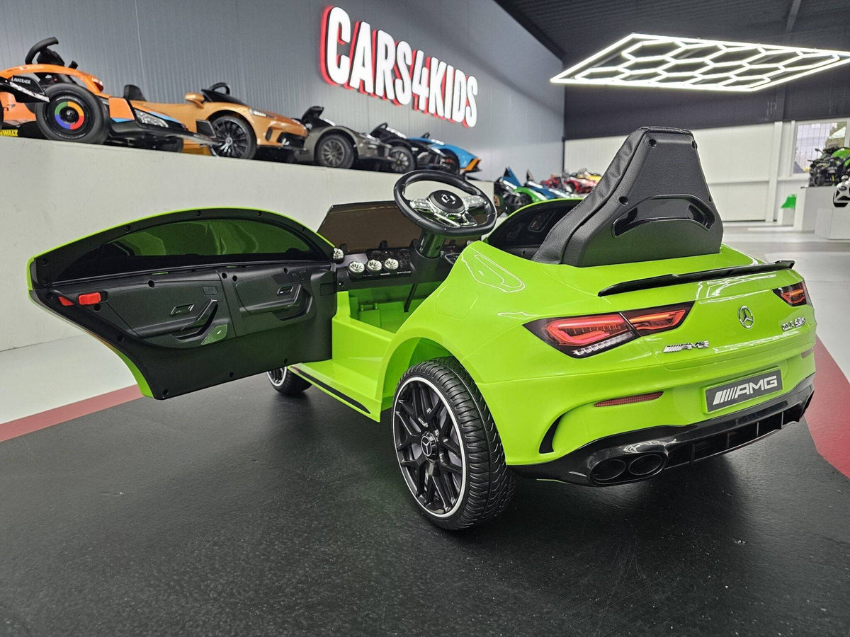 Retro dell'auto elettrica per bambini Mercedes CLA 45 verde con dettagli AMG, luci posteriori e sistema di scarico, ambiente di showroom