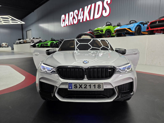 Auto elettrica per bambini BMW M5 24 V colore grigio metallizzato con sedile beige, dettagli realistici e dimensioni compatte, ideale per giochi all'aperto