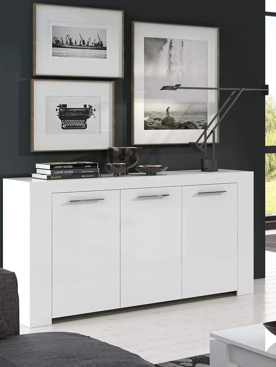 Mobile base bianco opaco L144 x P42 x H80 cm in un soggiorno moderno, decorato con lampada e quadri eleganti.