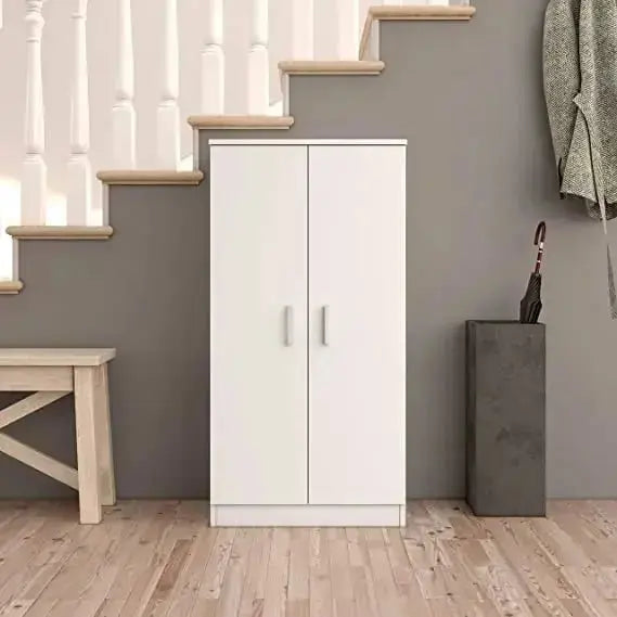 Scarpiera bianca a 2 ante collocata sotto una scala in un ingresso. Design elegante e funzionale per organizzare fino a 24 paia di scarpe.