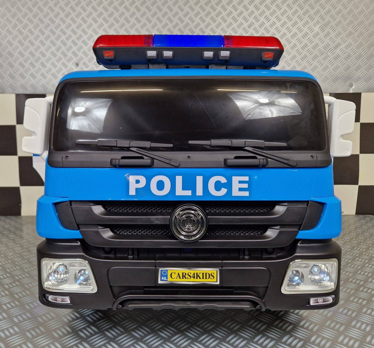 Retro del camion della polizia elettrico per bambini, con portelloni grigliati, dettagli di sicurezza e ruote robuste, colore blu e bianco.