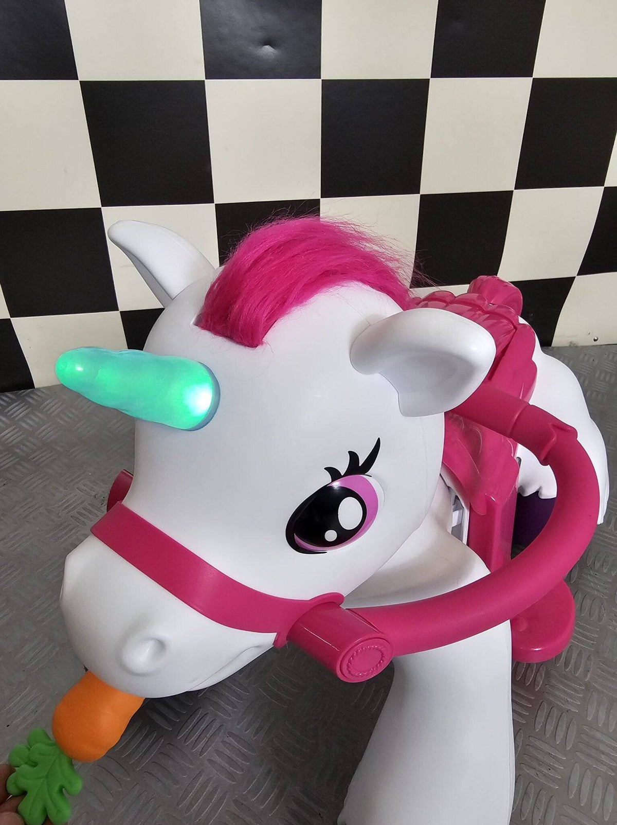 Vista laterale di un cavallo unicorno giocattolo elettrico bianco con criniera rosa, luci LED verdi e dettagli colorati, ideale per bambini