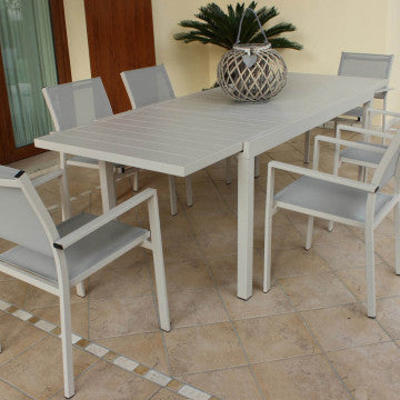 Tavolo Formentera tortora allungabile con sedie abbinate, ideale per pranzi all'aperto in giardino.