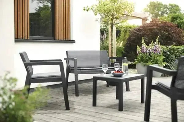 Set salotto da giardino Emily in grafite allestito su una terrazza, con piante decorative e atmosfera accogliente.