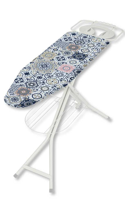 Tavolo da stiro in acciaio con piano rivestito in tessuto decorativo con motivi geometrici blu, beige e rosa, struttura bianca, portacaldaia integrato