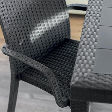 Dettaglio della Poltrona Indiana nera in wicker accanto a un tavolo. Ideale per ambienti esterni eleganti e funzionali.
