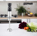 Frullatore a immersione Zephir 1000W in acciaio inox con manico nero, in cucina moderna con verdure e utensili, logo Zephir visibile