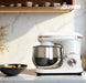 Impastatrice Zephir 1000W con ciotola in acciaio inox, posizionata su superficie bianca in cucina elegante, con logo Zephir visibile