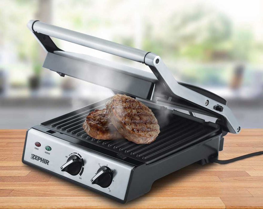 Bistecchiera elettrica Zephir 2000W con piastre antiaderenti, apertura a 180°, in uso con carne sulla piastra, controlli regolabili