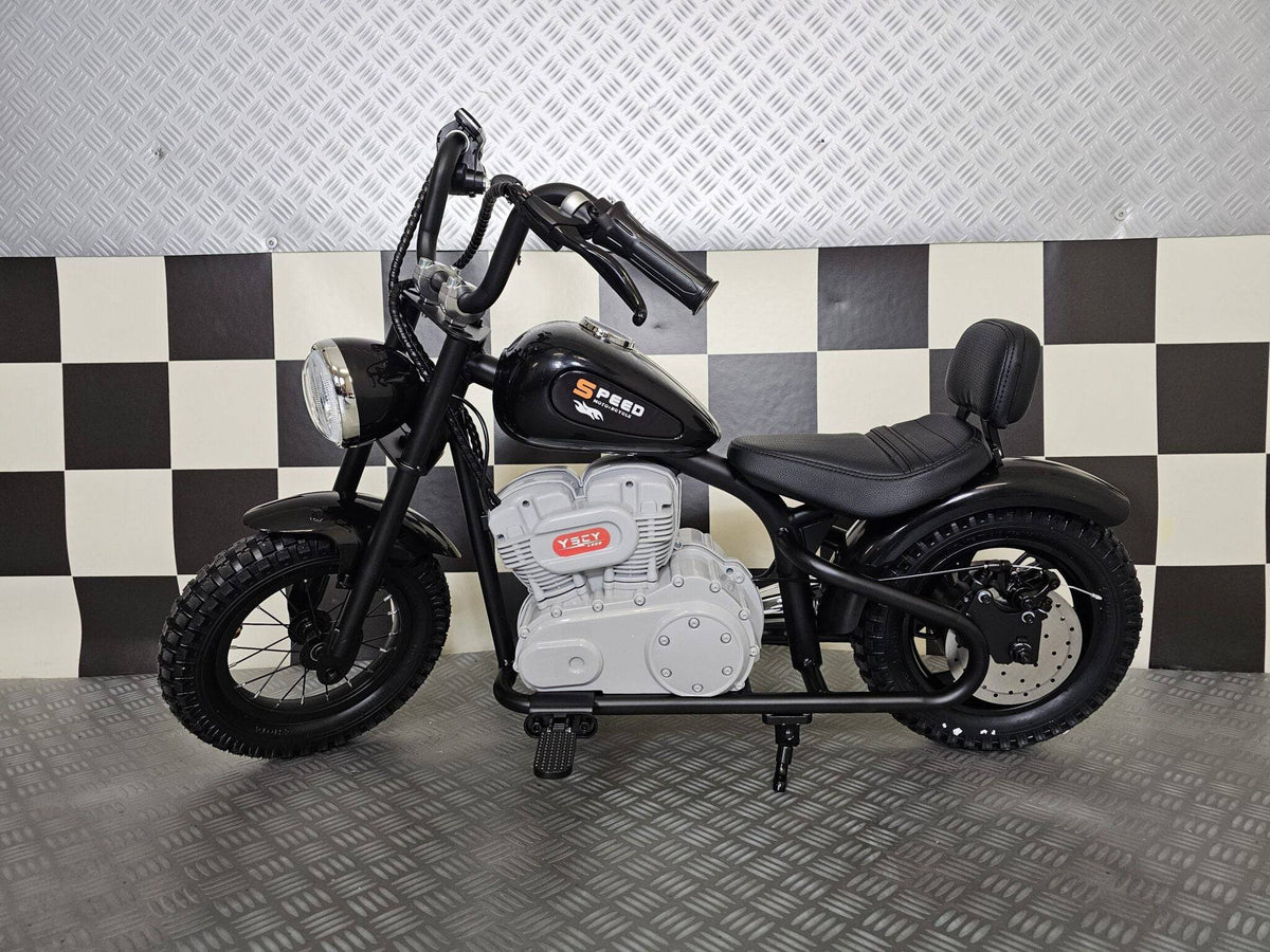Vista posteriore della moto elettrica per bambini modello chopper nero, con sedile in pelle, ruota posteriore grande e dettagli in stile motociclista.