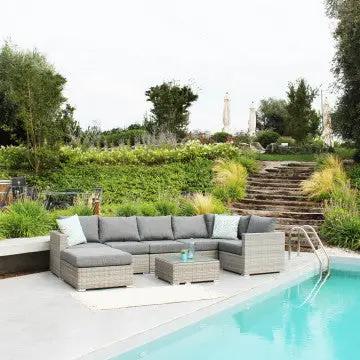 Arredo da esterno con divano modulare e Tavolino Copacabana in wicker grigio, perfetto per spazi all'aperto accanto alla piscina.