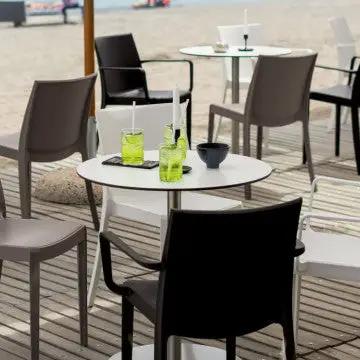 Poltrone Victoria in polipropilene bianco, taupe e antracite su terrazza da spiaggia, perfette per bar e ristoranti.
