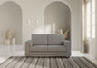 Divano Marrak 2 posti medio grigio in salotto elegante con tappeto a righe, perfetto per ambienti contemporanei.