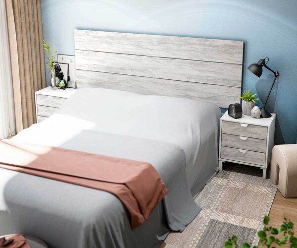 Testiera letto con grande pannello in legno bianco chiaro, abbinata a comodini bianchi con cassetti, in una camera moderna e luminosa.