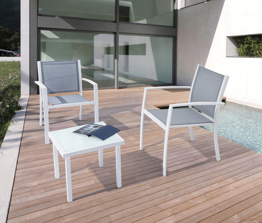 Salotto da Esterno Auri 3 Pezzi in acciaio bianco con sedute in texilene grigio su terrazza in legno accanto a piscina moderna. Tavolino con piano in vetro temperato, ideale per giardini e spazi outdoor eleganti.