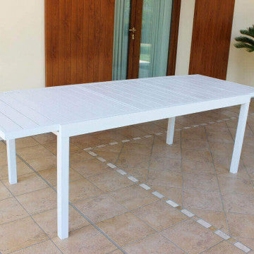 Tavolo Formentera bianco allungabile posizionato su veranda, perfetto per cene all'aperto.