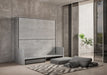 Letto a scomparsa Kando Sofà effetto cemento in fase di apertura, con divano trasformabile e materassi integrati, ideale per spazi multifunzionali.