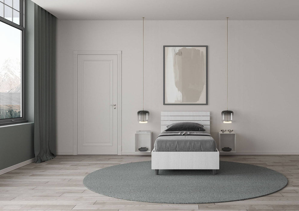 Letto singolo Ankel bianco in una camera luminosa con arredamento minimalista, ideale per ambienti moderni e raffinati.